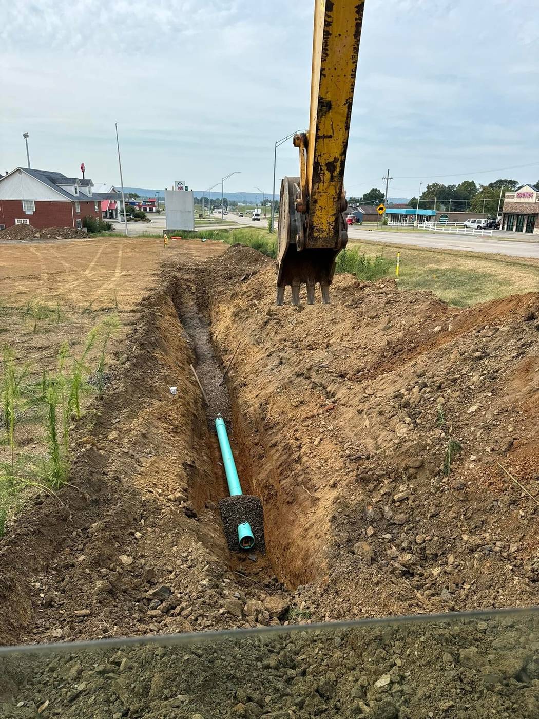 Excavator digging a trench during a dirt work project